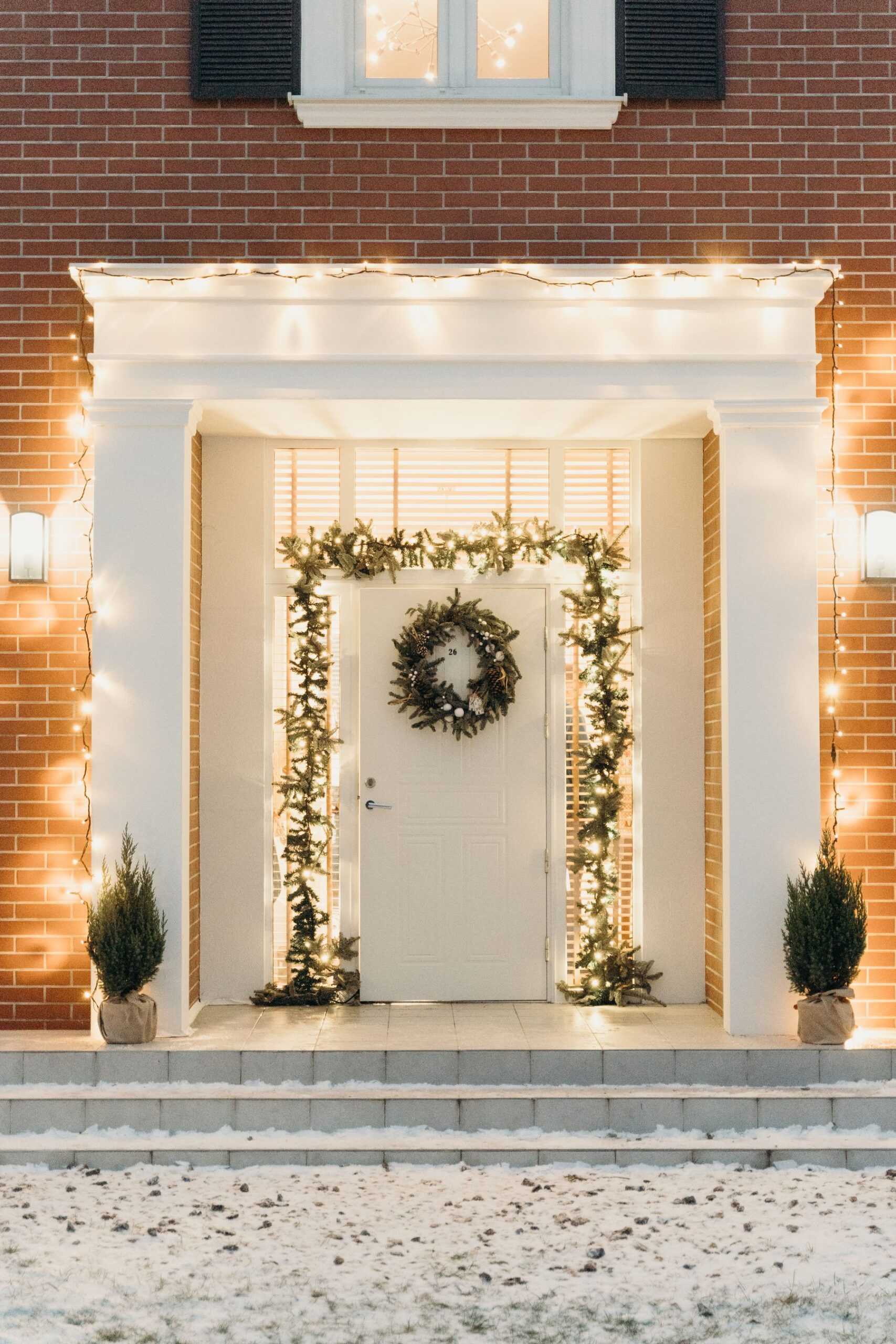 Front door of a Napa home framed with a lit garland and wreath