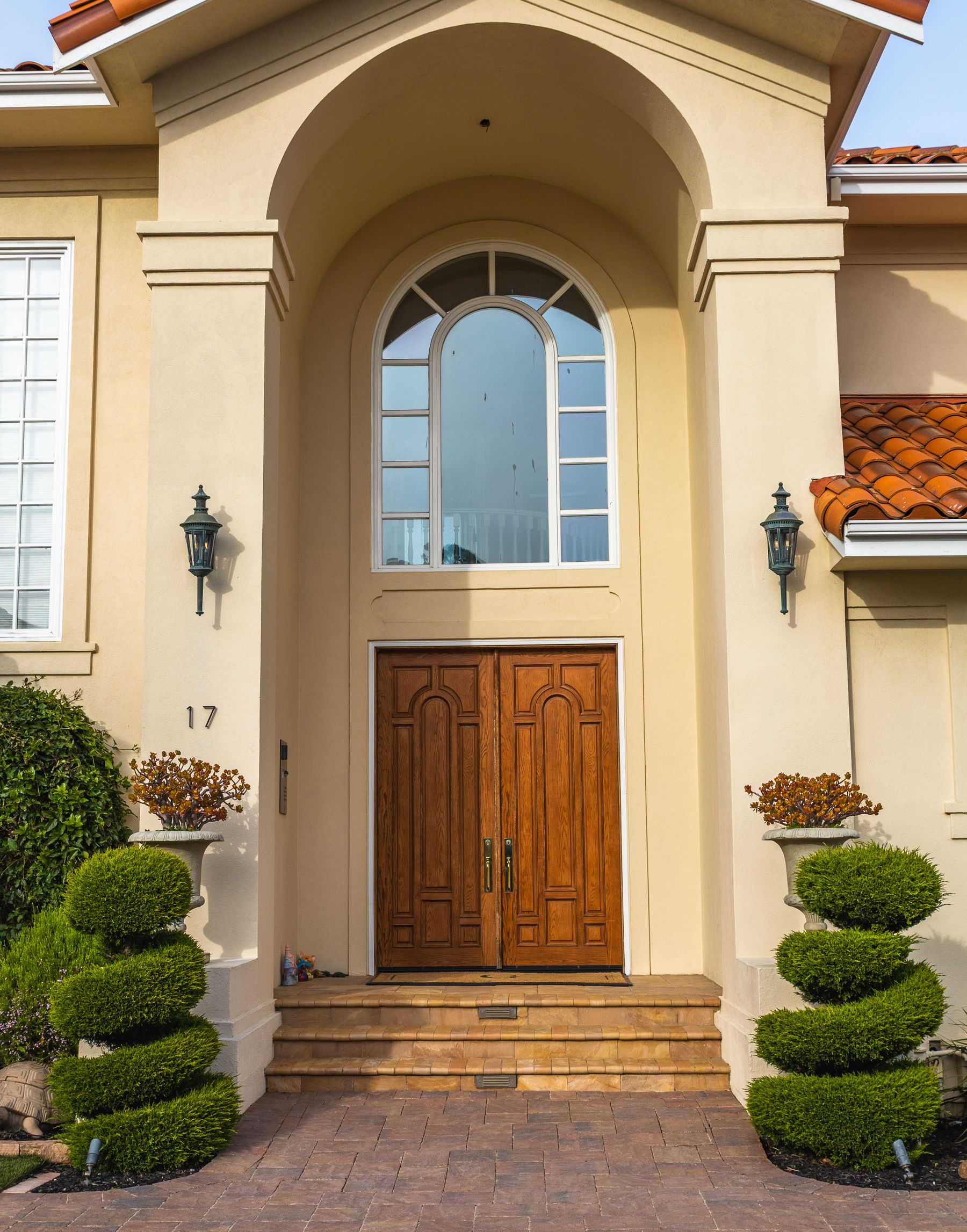 Stately stucco home entrance with architectural lighting